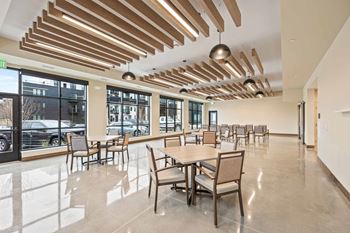 A large room with tables and chairs and a ceiling with wooden slats.